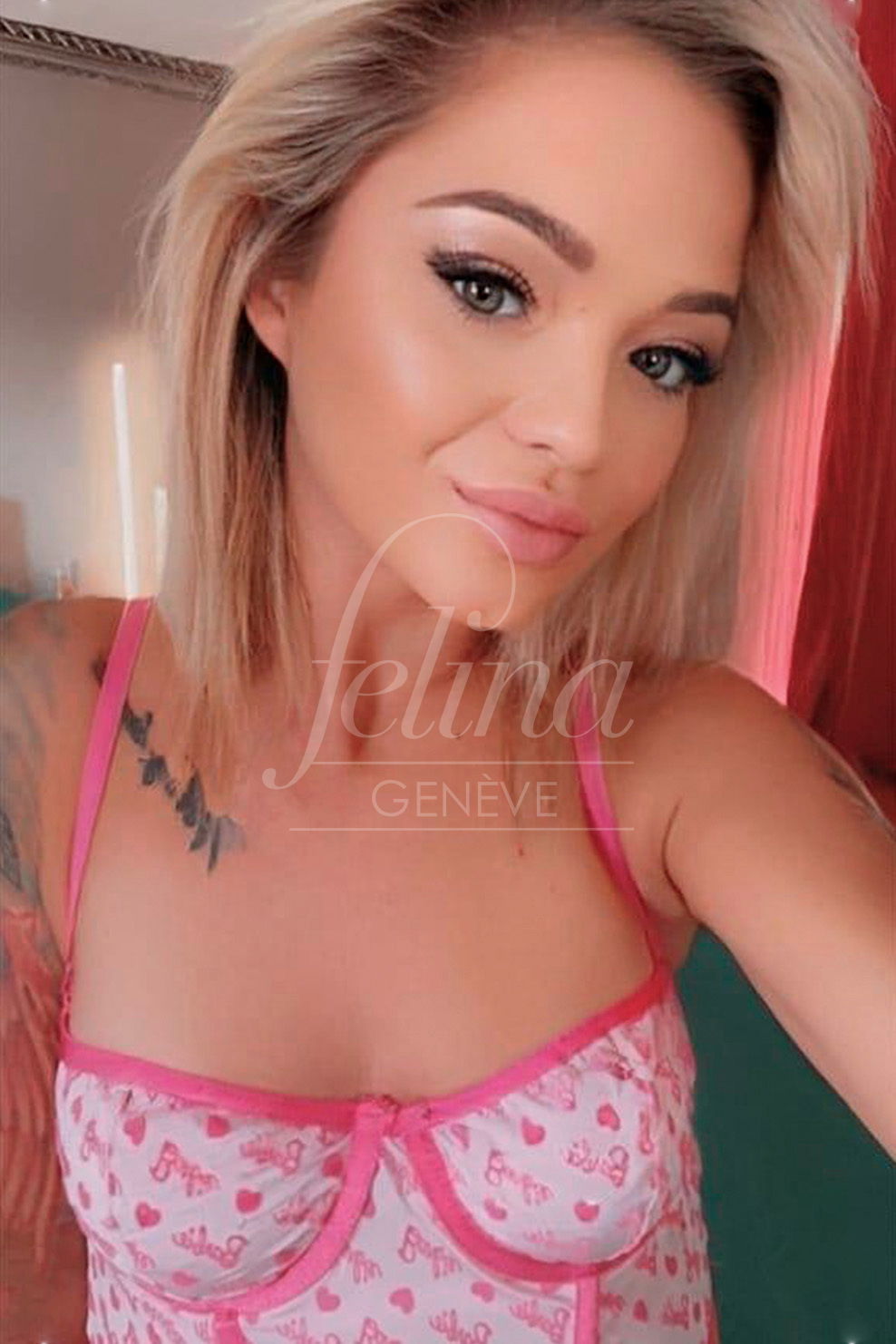 Escort blonde aux yeux bleus, tatoutée, se prenant un selfie